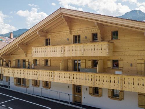 een groot houten gebouw met een balkon bij Apartment Grace by Interhome in Gstaad
