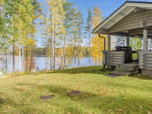 Un cenador con un banco en el césped cerca de un lago en Holiday Home Markenniemi by Interhome, en Ahveninen