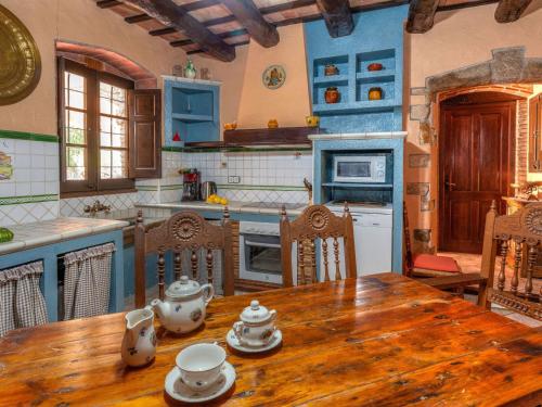 a kitchen with a wooden table and a kitchen with blue cabinets at Holiday Home Can Funei by Interhome in Calonge