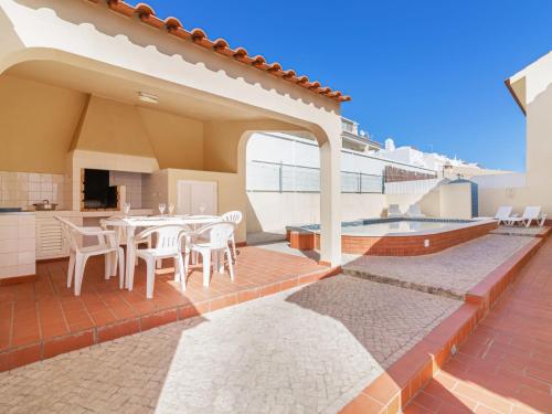 a patio with a table and chairs and a swimming pool at Villa Flor de Maio by Interhome in Patroves