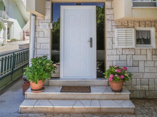 a white door on a house with potted plants at Holiday Home Nikica by Interhome in Brodarica