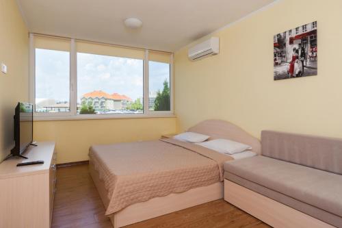 a bedroom with a bed and a couch and a television at Hotel Promenad in Zatoka