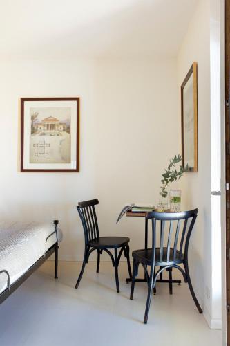 a bedroom with a table and two chairs and a bed at Porta Castellana B&B - Apartment in Montalcino