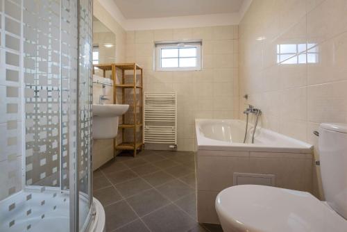 La salle de bains est pourvue de toilettes, d'une baignoire et d'un lavabo. dans l'établissement Villapark Vlašky, à Bešeňová