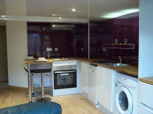 a kitchen with a washing machine and a washer at The Wee Thistle Loch Ness in Drumnadrochit