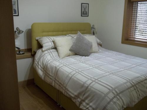 a bed with white pillows in a bedroom at The Wee Thistle Loch Ness in Drumnadrochit