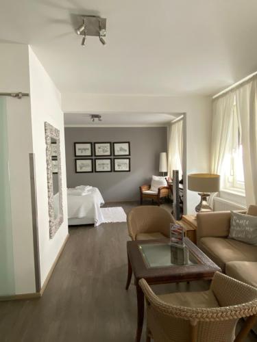 a living room with a couch and a bed at Bergland Hotel - Adults only in Salzburg