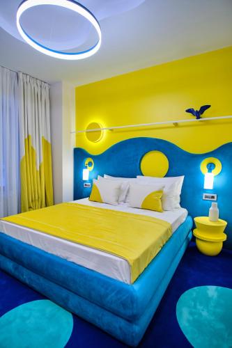a bedroom with a bed with a blue and yellow headboard at Vilacrosse Boutique Inn in Bucharest