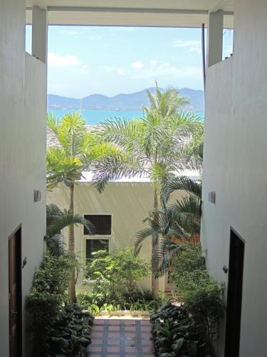 a view from the hallway of a building with palm trees at Davina Beach Homes in Panwa Beach