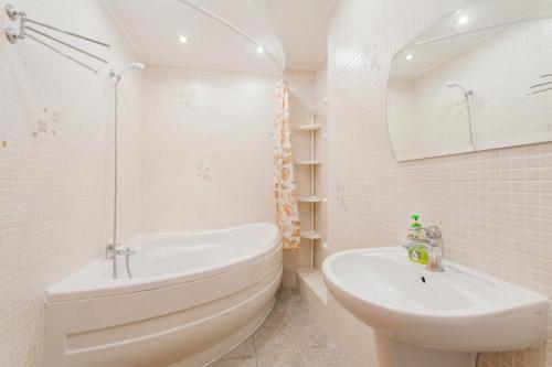 a white bathroom with a tub and a sink at Апартаменты возле МВЦ in Kyiv