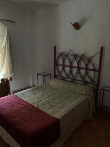 a bedroom with a bed with a metal headboard at Hostal Calderon Cuenca in Cuenca