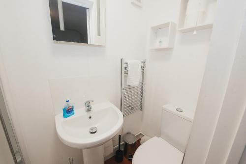 a white toilet sitting next to a sink in a bathroom at Home Sweet Home by Paymán Club in Cambridge