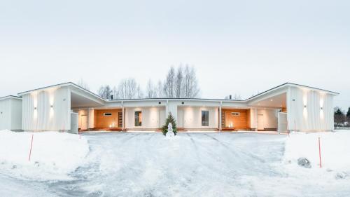 a building with snow on the ground in front of it at Luxury suites Pannunkorva C in Rovaniemi