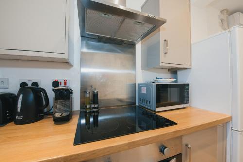 a kitchen with a microwave and a counter top at Home Sweet Home by Paymán Club in Cambridge