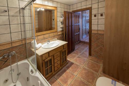 a bathroom with a tub and a sink and a shower at Bed and Snow Apartments in Sierra Nevada