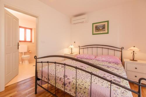 a bedroom with a bed with pink pillows at Villa Polonijo in Vrh