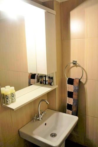 a bathroom with a sink and a mirror and a window at Zorbas Beach Village Hotel in Stavros