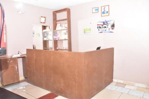 a brown reception desk in a white room at Viriko Boarding House in Mombasa