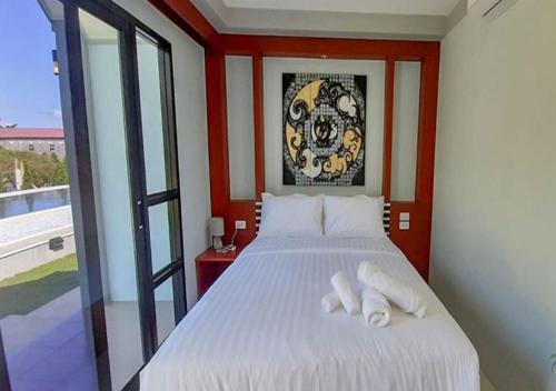 a bedroom with a white bed with towels on it at CC Beach Resort in Khanom