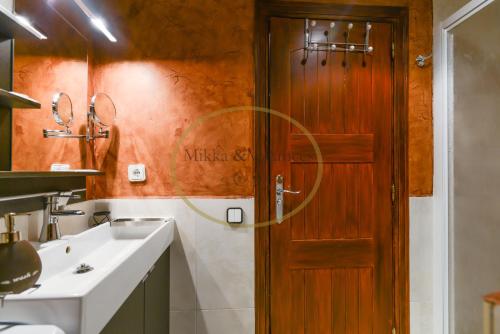 a bathroom with a wooden door and a sink at Mikka-TREMOL LUXE 33 in El Tarter