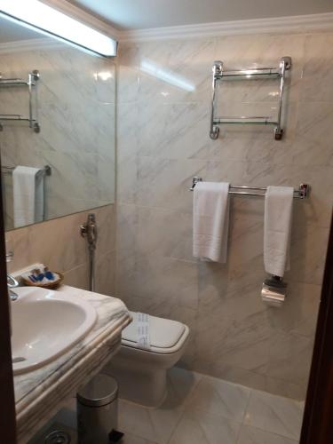 a bathroom with a sink and a toilet and a mirror at King Tut I Nile Cruise - Every Monday 4 Nights from Luxor - Every Friday 7 Nights from Aswan in Luxor