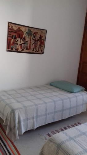 una camera con un letto e una foto appesa al muro di Dar el Baraka a Bizerte