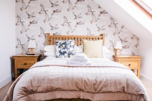 a bedroom with a large bed with two night stands at La Maison de Campagne in Kilmuir