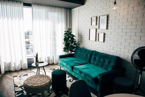 a living room with a green couch and a table at Wex 1 Apartments in Cape Town