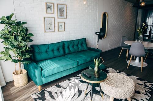 a green couch in a living room with a table at Wex 1 Apartments in Cape Town