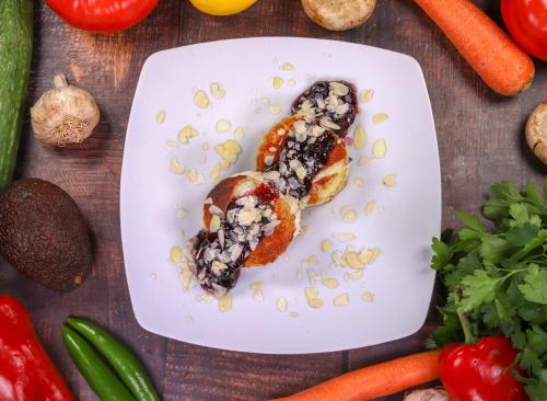 a white plate with food on a table with vegetables at Vila 6aTo Hotel & Wellnes in Sofia