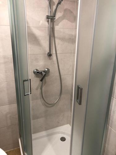 a shower with a glass door in a bathroom at Apartament dwa pokoje Dęblin in Dęblin
