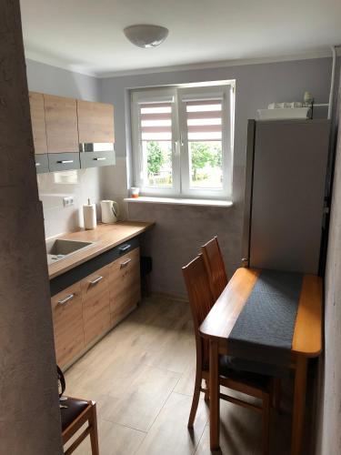 a kitchen with a table and chairs and a table and a kitchen with a kitchen at Apartament dwa pokoje Dęblin in Dęblin