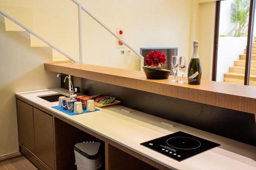a kitchen with a counter with a sink and a bottle of wine at Sheng Tu Villa in Hengchun