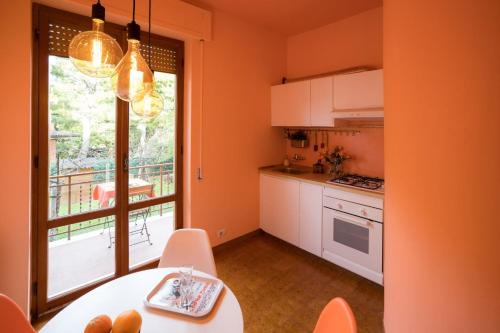 a kitchen with orange walls and a table and a window at Residenza dei Pini in Civitanova Marche