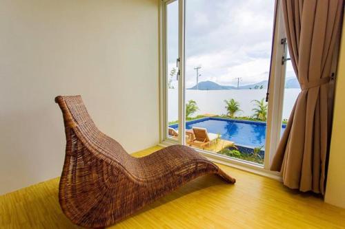 a rattan chair in a room with a view of a pool at Sheng Tu Villa in Hengchun