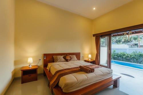 une chambre avec un lit et une grande fenêtre dans l'établissement Ayu Guest House 2, à Canggu