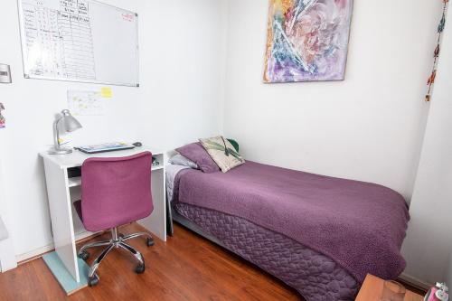 a bedroom with a bed and a desk with a computer at Habitación Providencia in Santiago