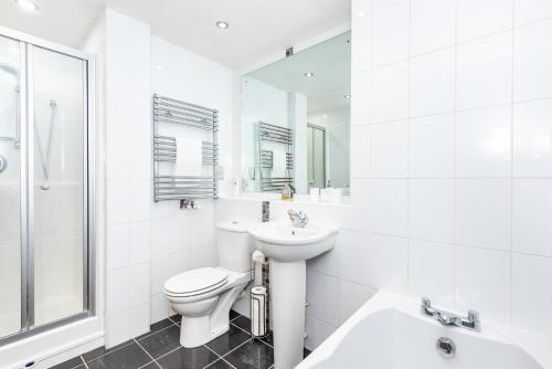 a white bathroom with a toilet and a sink at Modern Smart Open Plan Living with free Parking in York