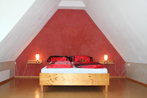 1 dormitorio con 1 cama con paredes rojas y 2 velas en FeWo am Schlossberg, en Neusitz