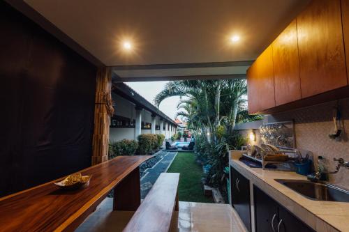 an open kitchen with a counter and a view of a yard at Ayu Guest House 2 in Canggu