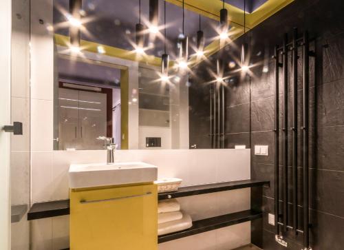 a bathroom with a sink and a mirror at Apartment KOBRO - new city center of Lodz in Łódź