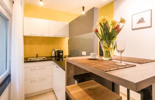 a kitchen with a counter with a vase of flowers at Apartment KOBRO - new city center of Lodz in Łódź