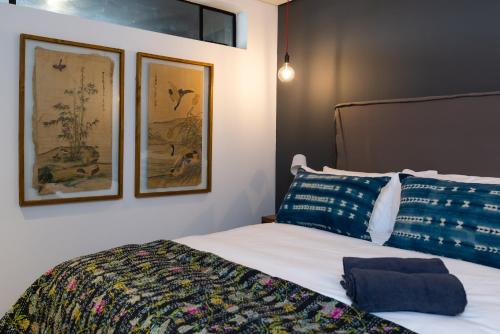 a bedroom with a bed with two pictures on the wall at Wex 1 Apartments in Cape Town