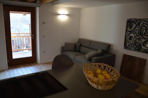 a living room with a table with a basket of fruit at Le Stanze di Klaus in Rovereto