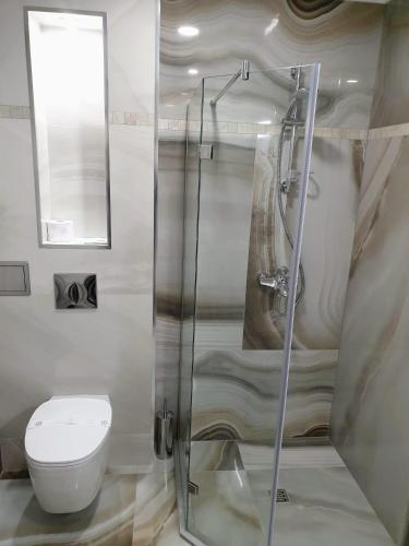 a bathroom with a toilet and a glass shower at Хотел ЦЕНТРАЛ in Stara Zagora