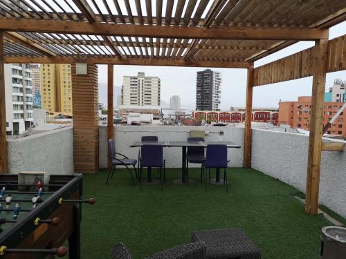 a patio with a table and chairs on a roof at Hotel Esmeralda in Iquique