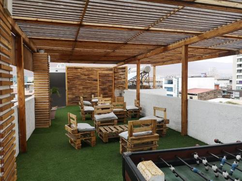 a patio with chairs and a pool table on a roof at Hotel Esmeralda in Iquique