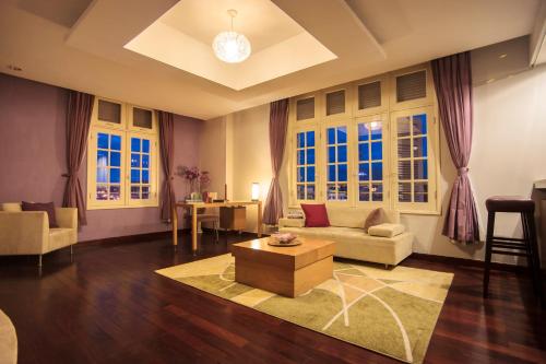 a living room with a couch and a table and windows at TTC Hotel - Ngoc Lan in Da Lat