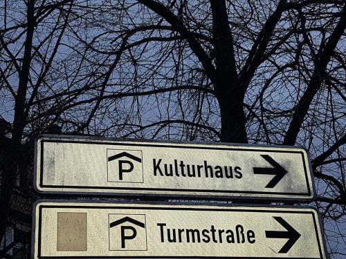 two street signs in front of a tree at Schillers Hotel & Café - GARNI - in Lüdenscheid