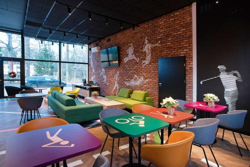 a room with tables and chairs and a brick wall at Enklawa Białowieska Forest & Spa in Hajnówka